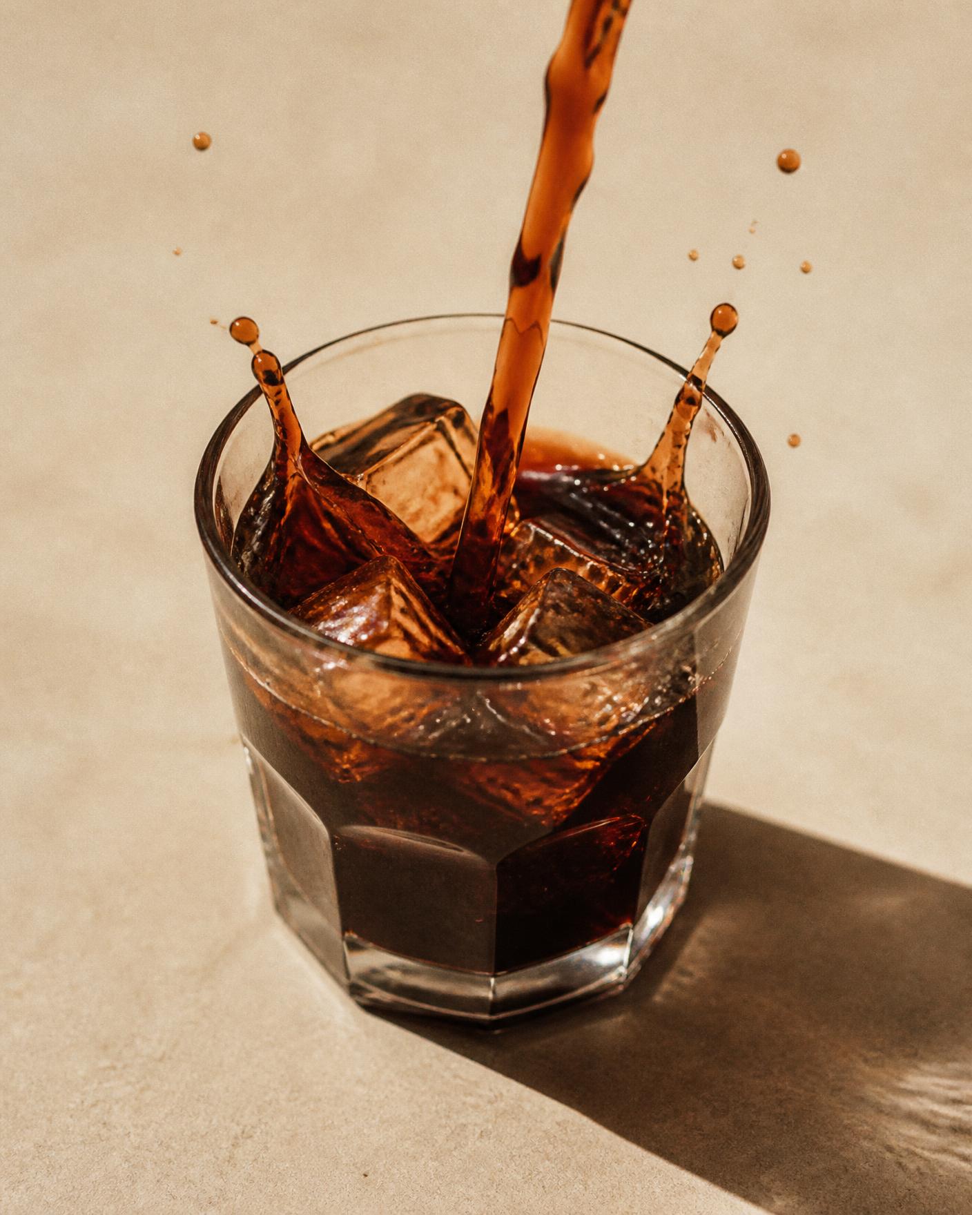 Cold brew coffee poured over ice in morning light